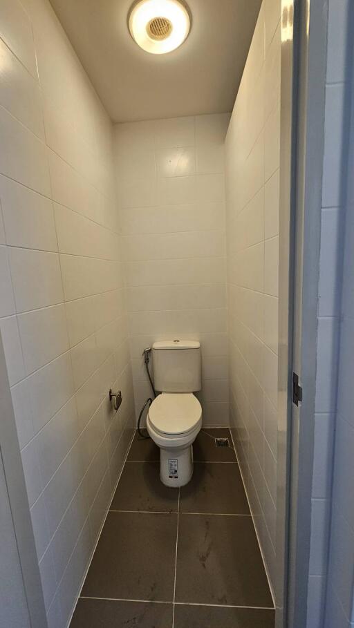 Compact bathroom with white tiles and modern toilet