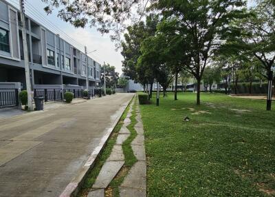 Residential complex exterior with townhouses and landscaped green area