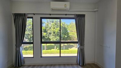 Bright bedroom with large windows and an air conditioning unit