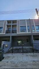 Modern multi-story residential building facade with balconies and parking space