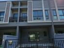 Modern multi-story residential building facade with balconies and parking space