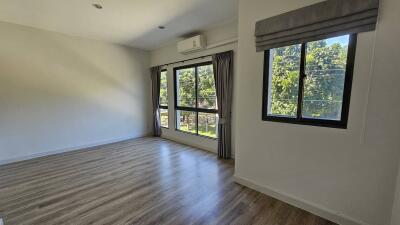 Spacious bedroom with natural light and air conditioning unit