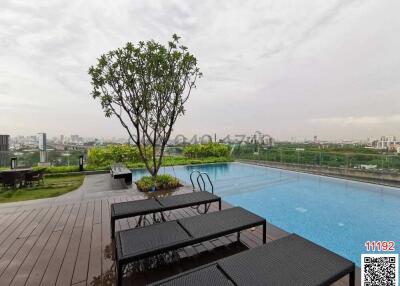 Rooftop pool with a city view and seating area