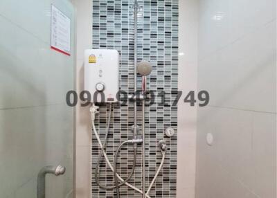 Modern bathroom with wall-mounted shower system and decorative tiles