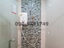 Modern bathroom with wall-mounted shower system and decorative tiles