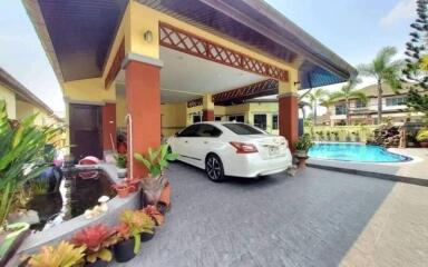 Spacious driveway with a vehicle parked in front of a house with a pool