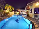 Evening view of a home's exterior with swimming pool and carport