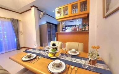 Cozy dining area with a wooden table set and modern kitchenette in the background