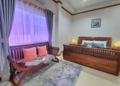 Elegantly furnished bedroom with king-sized bed and cozy seating area