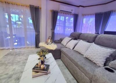 Contemporary living room with large grey sectional sofa and elegant curtains