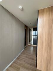 Modern hallway with wood flooring leading to rooms and balcony