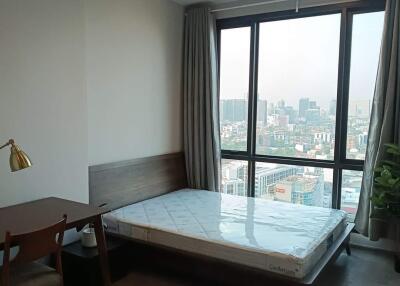 Spacious bedroom with large window overlooking the city