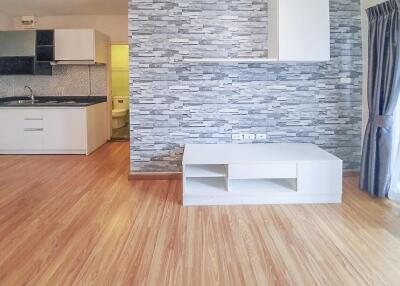 Modern kitchen with stone accent wall and wooden flooring