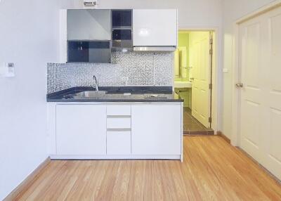 Modern kitchen with mosaic backsplash and wooden flooring