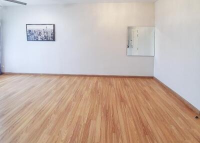 Spacious empty room with hardwood floors and white walls