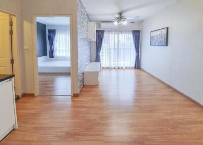 Spacious living room with hardwood floors and natural light