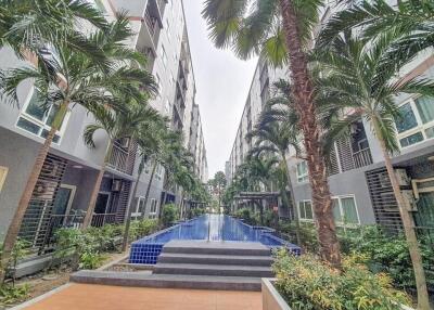 Modern apartment complex with central walkway and palm trees