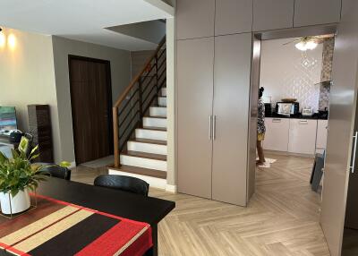 Modern interior view of a living space with staircase and kitchen entrance