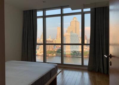Bedroom with large windows offering a city view