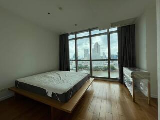 Spacious bedroom with large windows and city view