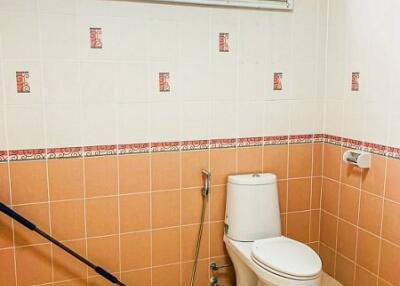 Compact tiled bathroom with a toilet and shower area