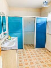 Bright bathroom with a glass shower partition and patterned tile flooring