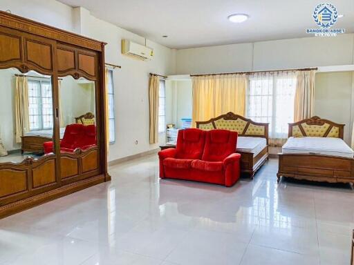 Spacious bedroom with a red sofa and wooden furniture