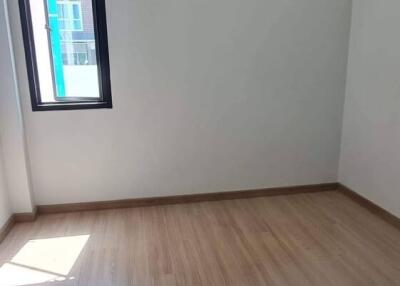 Empty bedroom with natural light and hardwood flooring