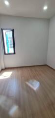 Empty bedroom with natural light and hardwood flooring