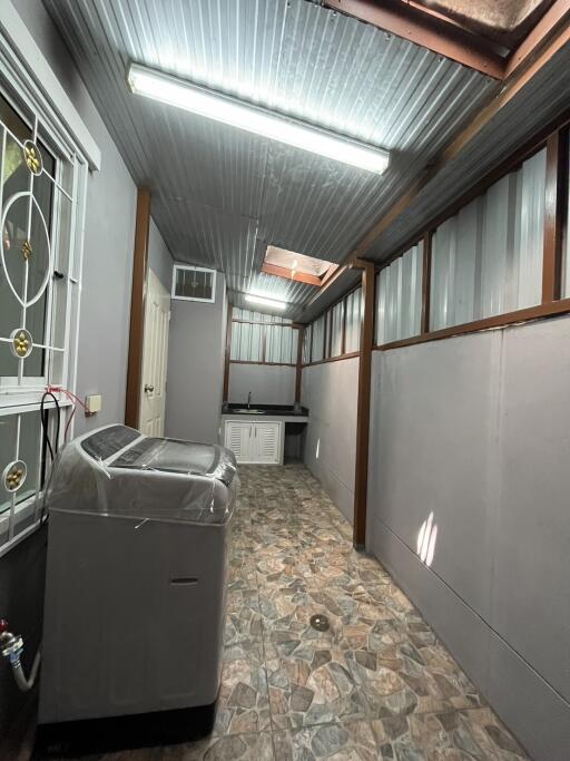 Compact laundry room with washer and ample storage space