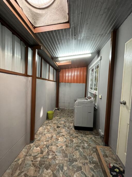 Corridor with washing machine and tiled flooring