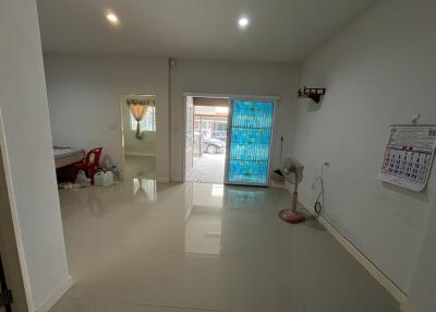 Bright and spacious living room with tiled flooring and large door - interior view