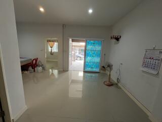 Bright and spacious living room with tiled flooring and large door - interior view