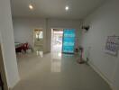 Bright and spacious living room with tiled flooring and large door - interior view