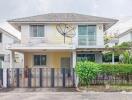 Two-story suburban house with a front gate and garden