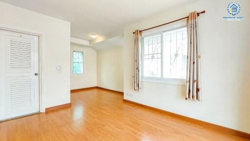 Spacious and well-lit empty living room with hardwood floors