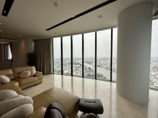 Spacious living room with large windows offering an expansive city and river view