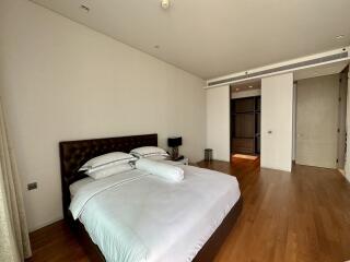 Spacious bedroom with wooden flooring and natural light