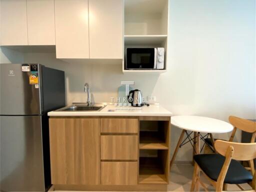 Compact modern kitchen with microwave and dining area