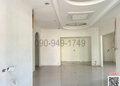 Spacious unfurnished interior of a building with white walls and tiled flooring
