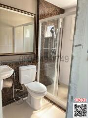 Compact bathroom with white fixtures, including a toilet and a glass shower cabin