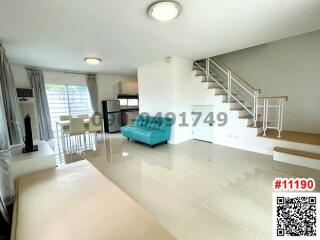 Bright and spacious living room with modern staircase and comfortable seating