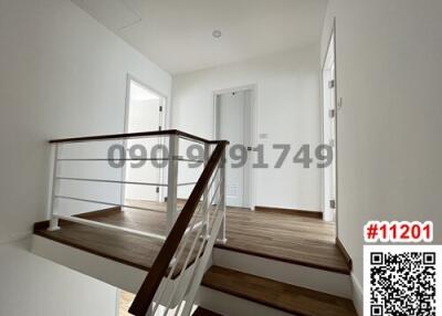 Modern hallway interior with wooden staircase and upper landing