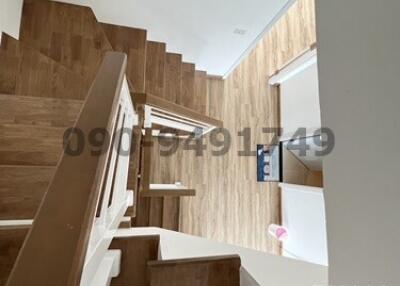 Modern wooden staircase with white balusters leading to upper level