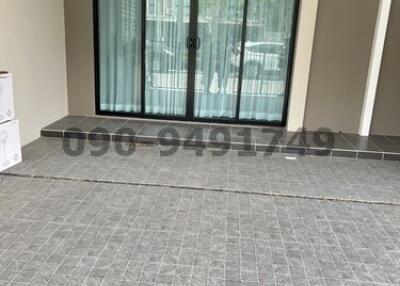 Empty interior space with large sliding glass doors and tiled flooring