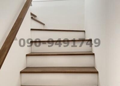Modern wooden staircase with white walls in a residential home