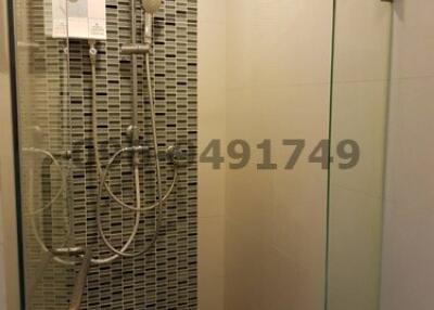 Modern glass-enclosed shower with mosaic tile wall
