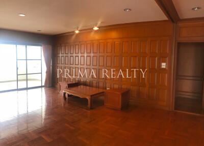 Spacious living room with wooden paneling and parquet flooring