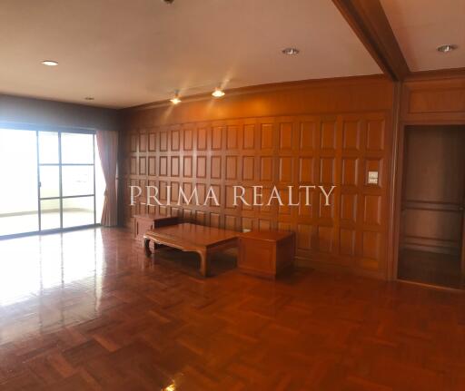 Spacious living room with wooden paneling and parquet flooring