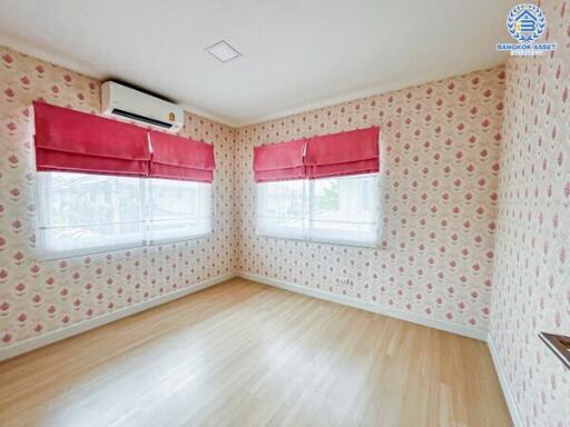 Spacious bedroom with floral wallpaper and large windows